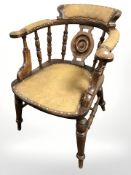An Edwardian beech spindle back armchair, with studded faux leather covering.