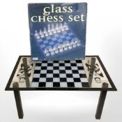 A chessboard coffee table, width 75 cm, and a glass chess set.