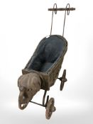 A Victorian wicker dolls pram, height 52 cm.