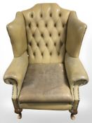 A 20th century Chesterfield tanned buttoned leather wingback armchair and two matching footstools.