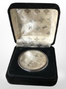 A Merck one hundred years commemorative one troy ounce fine silver coin.