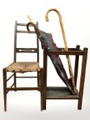 An Edwardian oak umbrella stand containing walking stick, two umbrellas,