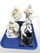 Two painted cast iron Michelin man figures and three further plastic figures.