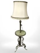 An ornate gilt brass and onyx standard lamp incorporating a table with tasseled shade,