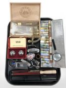 A tin containing artist's paint pigments, glass test tubes, small scale, magnifying glass,