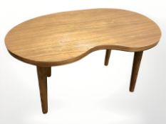A teak kidney-shaped coffee table on tapering legs, width 80 cm.