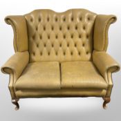 A Chesterfield tan buttoned leather two seater wing back settee,