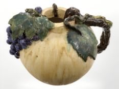 A large earthenware jug decorated with grapes and vines, height 27 cm.