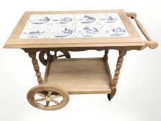 A Dutch oak and delft tile inset drinks trolley, length 83 cm.