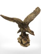 A resin figure of an eagle on rock, height 31 cm.