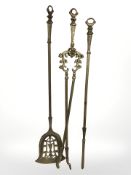 A cast brass three piece fire companion set.