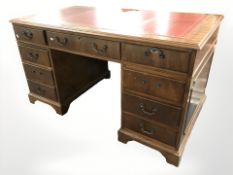 A reproduction mahogany nine drawer twin pedestal desk, 137 cm x 77 cm x 77 cm.