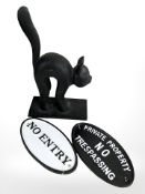 A cast iron figure of a cat, height 26 cm, and two further warning signs.