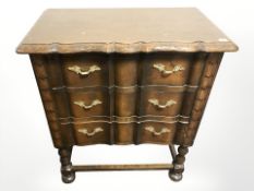 A carved oak three drawer serpentine chest,
