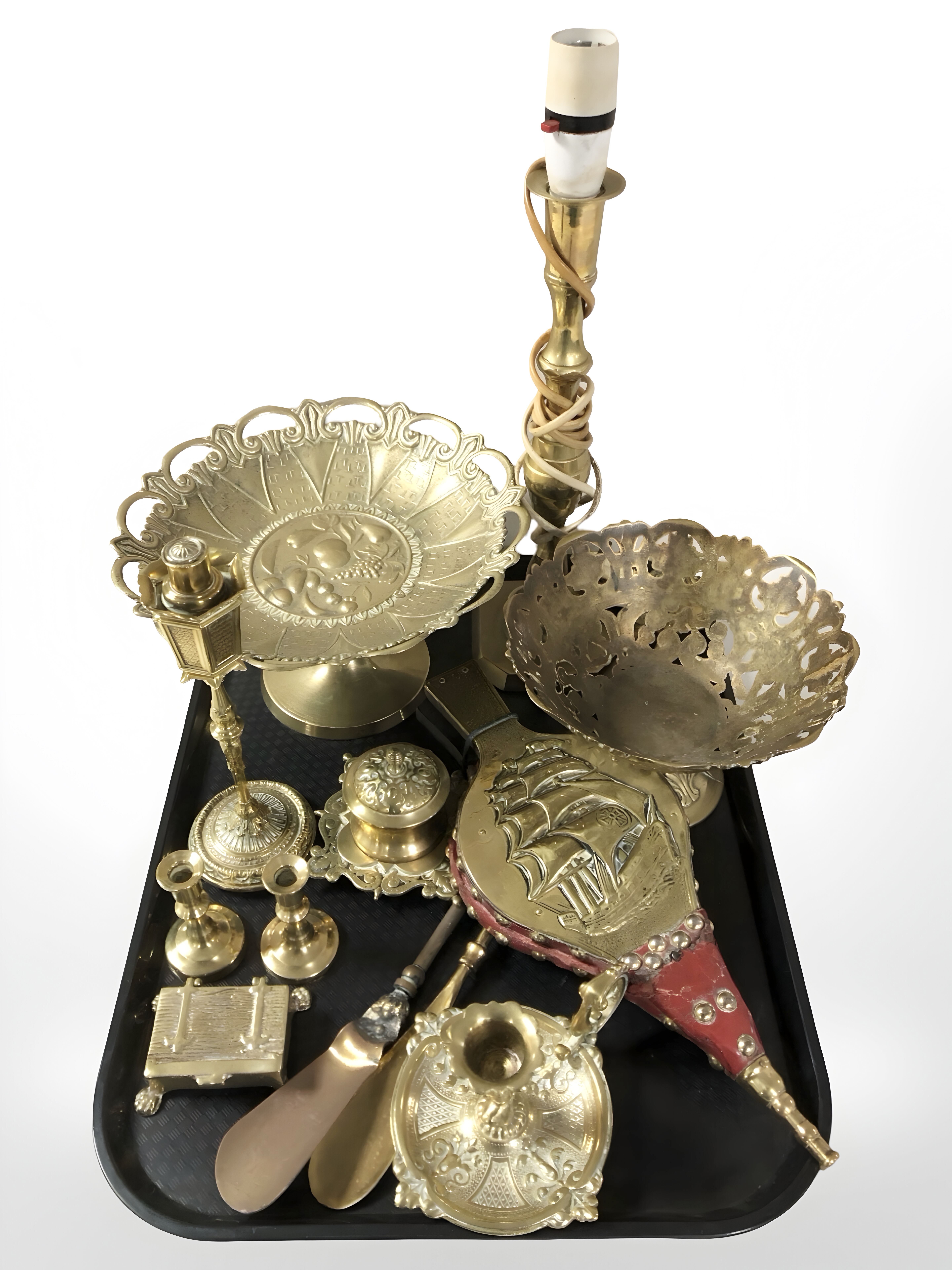 A brass lamp base, pedestal dishes, candlesticks, bellows, etc.