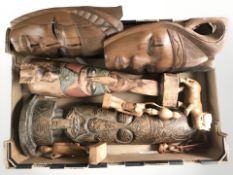 A group of carved hardwood tribal masks and figurines.