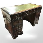 A reproduction mahogany and green tooled leather inset twin pedestal writing desk,