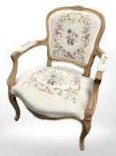 A continental carved and embroidered salon armchair.