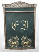 An antique carved oak frame with heraldic embroidery, 75 cm x 112 cm.