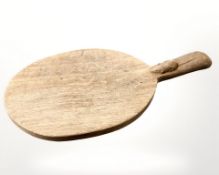 A Robert 'Mouseman' Thompson of Kilburn oak cheese board, with carved mouse signature, length 37 cm.