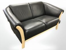 A contemporary Danish wooden framed black leather two seater settee, length 150 cm.
