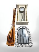 A continental and painted gilt wall clock, a wrought metal mirror and a bundle of walking sticks,