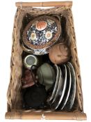 A wicker basket of oriental wares including Japanese imari plates, cast iron tea pot,