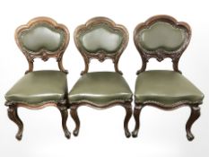 A set of nine early 20th century mahogany and studded olive green leather dining chairs.