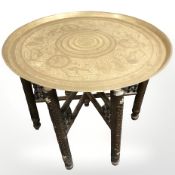 A Syrian carved hardwood and bone inlaid folding occasional table with engraved brass top,