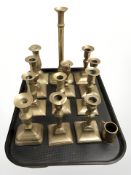 A collection of Victorian brass candlesticks and a small mug, tallest 31 cm.