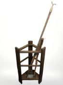 An Edwardian oak stick stand containing two walking sticks and a window pull.