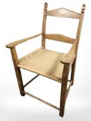 An oak and rattan armchair in the Arts and Crafts style