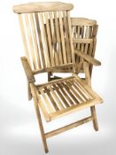A teak garden table and a pair of folding chairs