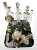 Three early 20th century oil lamps with green glass reservoirs,
