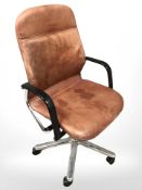 A chrome and tan leather swivel office chair.