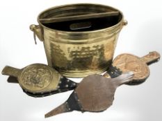 A two division brass bucket containing three pairs of antique bellows.