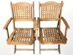 A pair of folding teak lattice back garden armchairs,