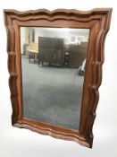 A 19th century shaped walnut wall mirror, 88 cm x 65 cm.