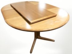 A contemporary teak veneered extending dining table with two leaves,