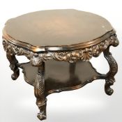 A continental heavily carved and stained beech two tier coffee table,