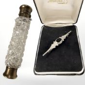 A cut glass double sided scent bottle, length 14 cm, and a silver brooch.