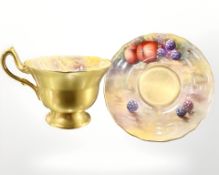 A Royal Worcester porcelain teacup and saucer, each hand-painted with panels of fruit,