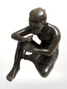 A hollow cast and patinated bronze figure of a seated man playing a flute, height 27.5 cm.