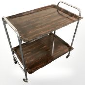 A chrome and rosewood effect two tier trolley, width 64 cm.
