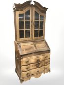 An early 20th century oak serpentine front bureau bookcase, 105 cm x 58 cm x 225 cm.