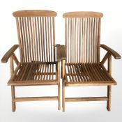 A set of four folding teak garden armchairs