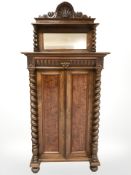 An early 20th century walnut double door cabinet with mirror back above,