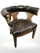 An early 20th century oak and studded leather horseshoe armchair, width 77 cm.