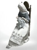 A Lladro figure of a seated lady doing embroidery, height 28 cm.