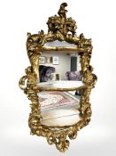 An ornate reproduction three-tiered mirror, 95 cm x 53 cm.
